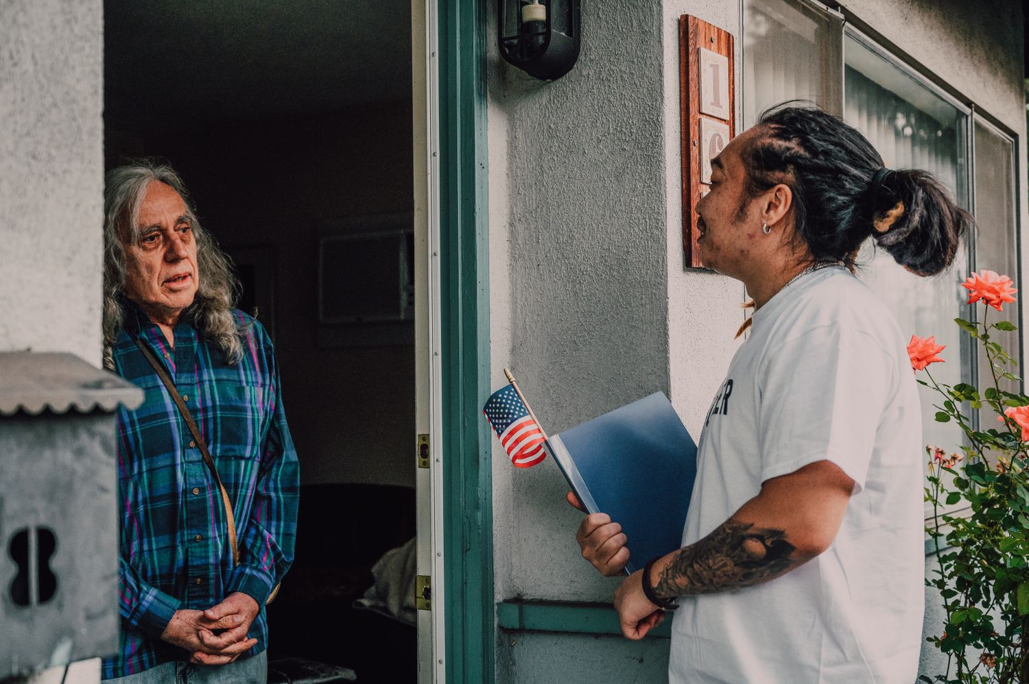 A volunteer talking with a voter at their doorstep